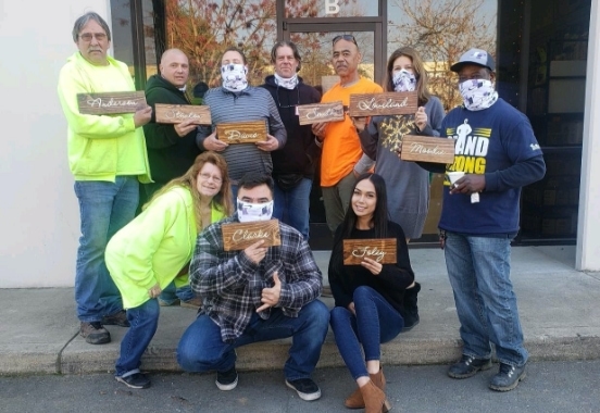 a group of people holding up a wooden signage