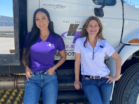 Two women in front of a truck