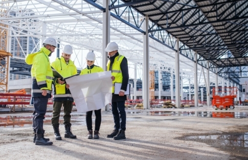 A group of people in hard hat discussing a construction project